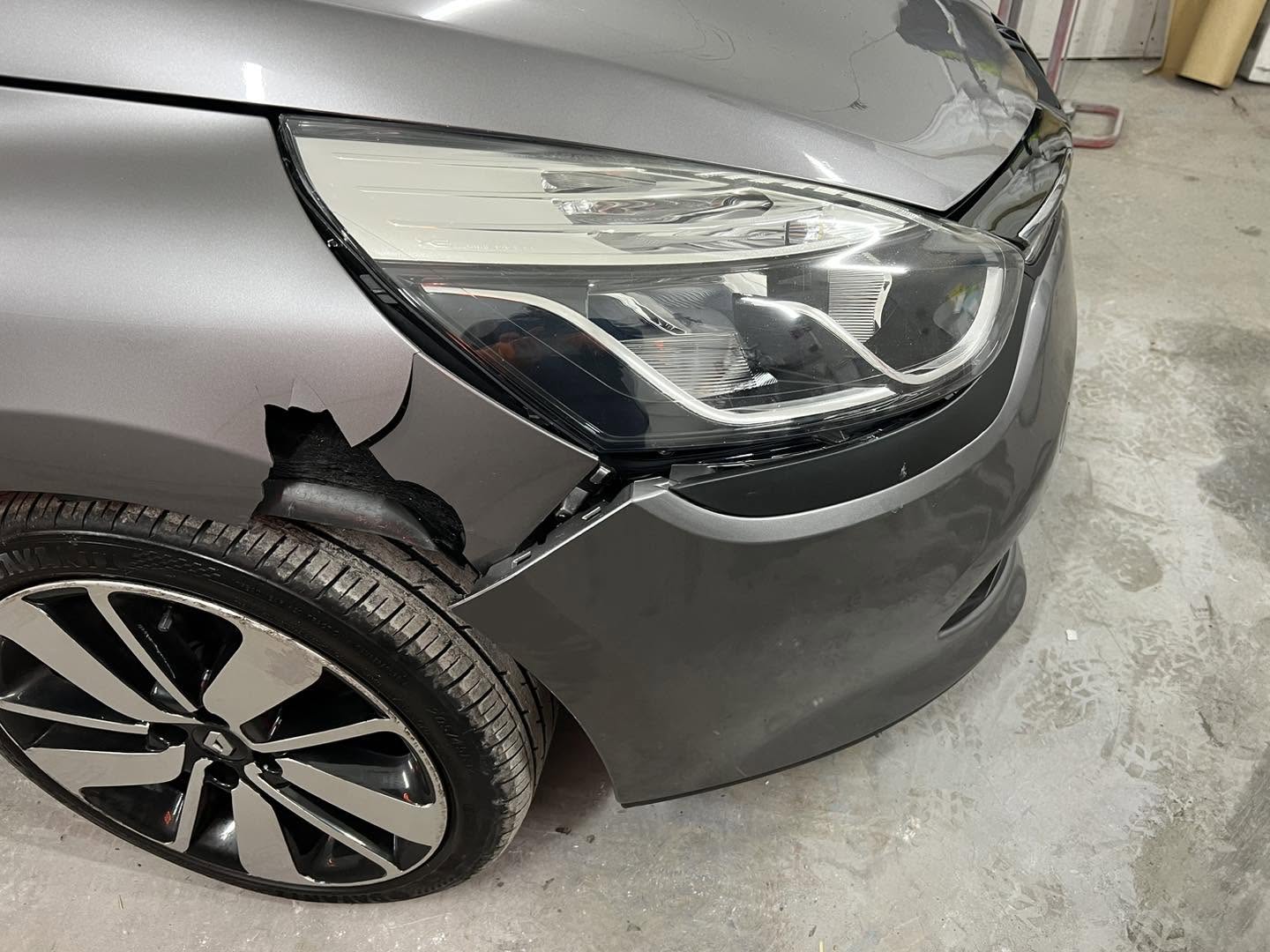 Renault with a damaged front wing beside the headlight